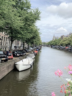 Blick auf Amsterdamer Gracht mit Boten
am Rand Bäume und Autos ;)